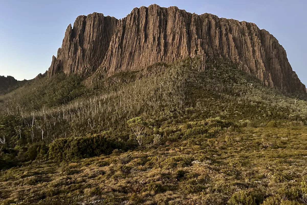 A columnar dolerite cliff in the Tasmanian highlands, lit low by evening sun